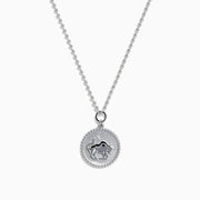 The Zodiac 925 Sterling Silver and Diamond Taurus Necklace features a round pendant with a raised bull design in the center, symbolizing Taurus, and is accented by a beaded edge.