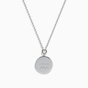 The Zodiac 925 Sterling Silver and Diamond Aquarius Necklace features a round, textured pendant engraved with a kneeling figure in prayer, offering a subtle yet meaningful tribute to the Aquarius sign.