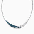 The Bella Bleu 14K White Gold Blue and White Diamond Necklace showcases an elegant asymmetrical design with overlapping curves and a section adorned with sparkling blue stones.