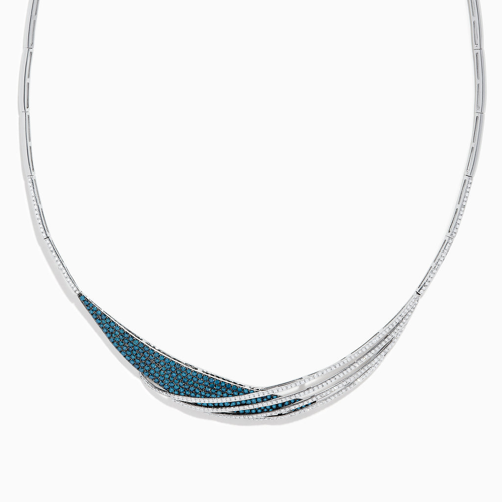 The Bella Bleu 14K White Gold Blue and White Diamond Necklace showcases an elegant asymmetrical design with overlapping curves and a section adorned with sparkling blue stones.