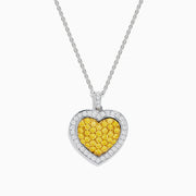 The 18K Two Tone Gold White and Yellow Diamond Heart Cluster Pendant features a heart shape bordered with white diamonds and a center of yellow diamonds, creating a vibrant, elegant design.