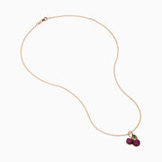 The 14K Rose Gold Ruby and Tsavorite Pavé Double Cherries Pendant features two round ruby pavé cherries and a sparkling tsavorite leaf accent on a delicate rose gold necklace.