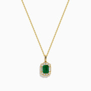 The 14K Yellow Gold Emerald and Diamond Halo Pendant features a rectangular green emerald, surrounded by round and baguette diamonds in a halo setting, all centrally suspended from a delicate gold chain.