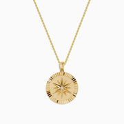 The D'Oro 14K Yellow Gold Diamond Compass Coin Pendant features a round medallion with a compass-inspired design, accented by a diamond at the center and suspended from a delicate yellow gold chain.