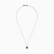 The 14K Two Tone Gold Emerald and Diamond Double Halo Pendant features a central green emerald surrounded by two rows of sparkling diamonds, all suspended from a delicate chain, showcased on a white background.