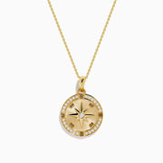 The 14K Yellow Gold Diamond Compass Rose Medallion Pendant features a round diamond compass design with a central gemstone and sparkling border, elegantly suspended from a delicate gold chain.