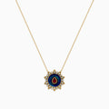 14K Yellow Gold Ruby, Diamond, and Enamel Pendant featuring a delicate gold chain, round pendant with blue and green enamel, a central ruby teardrop, and a sunburst of small clear stones.