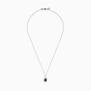 The Nahla Siri 14K White & Rose Gold Tanzanite and Diamond Pendant features an oval tanzanite surrounded by a double halo of diamonds, all set on a delicate silver chain and photographed against a white background.