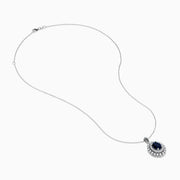 The Royal Bleu 14K White Gold Sapphire & Diamond Halo Pendant features a vibrant sapphire framed by two rows of sparkling white diamonds, all set in a chain necklace against a plain white background.