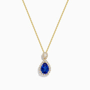 The Nahla Siri 14K Yellow Gold Tanzanite and Diamond Pendant features a teardrop blue tanzanite surrounded by white diamonds, plus a circular diamond accent above the main stone.
