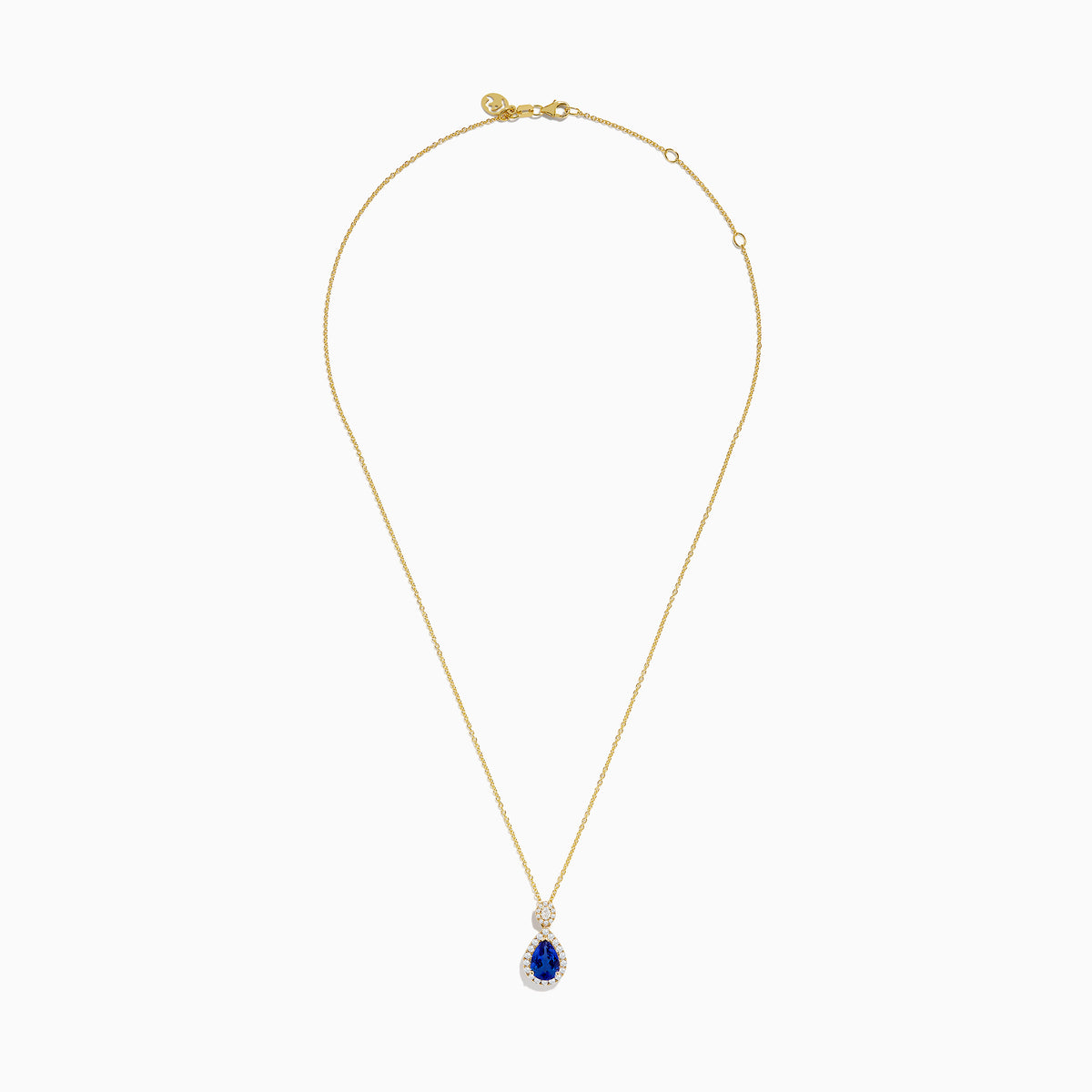The Nahla Siri 14K Yellow Gold Tanzanite and Diamond Pendant features a teardrop blue tanzanite surrounded by white diamonds, plus a circular diamond accent above the main stone.