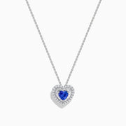 The Nahla Siri 14K White Gold Tanzanite and Diamond Heart Pendant showcases a vivid tanzanite at its center, encircled by sparkling diamonds, all set in white gold and displayed against a plain white background.