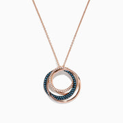 The 14K Rose Gold Blue and White Diamonds Circle Pendant showcases three interlocking circles, with two adorned by sparkling blue and white diamonds, beautifully presented against a white background.