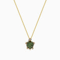 The 14K Yellow Gold Tsavorite and Diamond Turtle Pendant features a turtle-shaped design with a shell adorned in vibrant green tsavorites and sparkling diamonds on its head and feet, set against a plain white background.