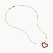 The 14K Yellow Gold Ruby and Diamond Pave Heart Pendant features an open heart design set with alternating red rubies and white diamonds on a gold chain.