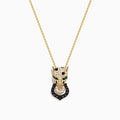 The Signature 14K Yellow Gold White and Black Diamond Panther Pendant features a panther head with white and black diamonds, green accents for the eyes, and a ring in its mouth.