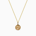 The 14K Yellow Gold Diamond Star of David Pendant features a round pendant adorned with sparkling diamonds, hanging from a delicate gold chain and showcased against a white background.
