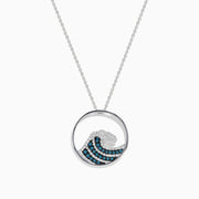 The Seaside 14K White Gold Blue and White Diamond Wave Pendant features a circular design with sparkling gems on a delicate chain, offering an elegant and airy style.