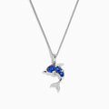 The 925 Silver Tanzanite and Diamond Dolphin Pendant features tanzanite-blue gems on the body and sparkling diamonds on the tail, elegantly showcased against a white background.