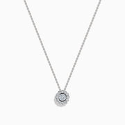 The 14K White Gold Diamond Bezel Halo Pendant features a delicate white gold chain with a round, flower-like diamond pendant, showcasing a central diamond surrounded by a halo of smaller diamonds.