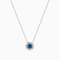 The Bella Bleu 14K White Gold Blue and White Diamond Pendant (1.60 TCW) features a flower-shaped design with a central blue stone and sparkling white diamonds, suspended on a fine chain against a plain white background.