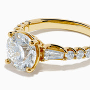 The Star Lab Grown Diamond Ring in 18K Yellow Gold showcases a large oval-cut lab diamond center stone with smaller rectangular accents along the band, elegantly displayed on a plain white background.