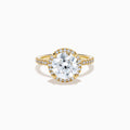 The Star Lab Grown Diamond Halo Ring in 18K Yellow Gold showcases a large oval lab diamond center, encircled by a halo of star lab diamonds and additional diamonds along the band for extra brilliance.
