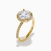 The Star Lab Grown Diamond Halo Ring in 18K Yellow Gold showcases a large oval lab diamond center, encircled by a halo of star lab diamonds and additional diamonds along the band for extra brilliance.