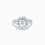 The Star Lab Grown Diamond Fleur Ring in 18K White Gold showcases a large round center lab diamond, with a sparkling halo of smaller diamonds and extra diamonds set along the band.