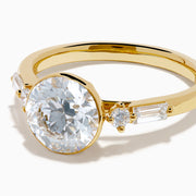 The Star Lab Grown Diamond Moderne Ring in 18K Yellow Gold features a large round lab diamond center, two smaller round diamonds, and baguette-cut side diamonds, shown on a white background.