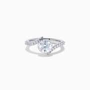 The Star Lab Grown Diamond Connect Ring in 18K White Gold showcases a striking round center stone, with an elegantly twisting band highlighted by sparkling side diamonds for extra brilliance.