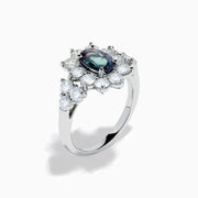 A Platinum GIA Certified Alexandrite and Diamond Starburst Halo Ring, featuring an oval dark blue-green central Alexandrite and sparkling diamond accents, displayed on a white background.