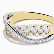 The 14K Two Tone Gold Diamond Criss Cross Ring features two overlapping bands, one set with white diamonds and the other with alternating white and yellow diamonds, finished with elegant polish and intricate detailing.