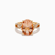 The 14K Rose Gold Morganite and Diamond Twist Band Ring features an oval peach morganite center stone with rows of white diamonds on a unique twist band, shown against a white background.