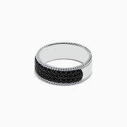 The Mens 925 Sterling Silver Black Sapphire Ring features a round, smooth, reflective top and sides adorned with small black sapphires, presented against a white background.