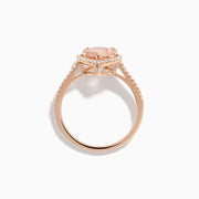 The Blush 14K Rose Gold Morganite and Diamond Ring features a large pear-shaped morganite framed by a halo of sparkling diamonds, with additional diamonds set along the band for added brilliance.