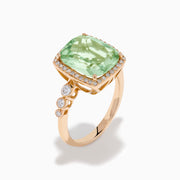 The 14K Rose Gold Green Amethyst and Diamond Halo Cocktail Ring showcases a rectangular light green amethyst center, framed by a sparkling diamond halo with round diamonds accenting the band.