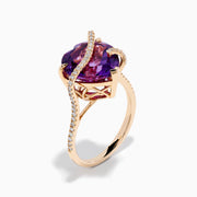 The 14K Rose Gold Amethyst and Diamond Heart Ring features a large heart-shaped amethyst set in rose gold, accented by a diamond-encrusted band, shown on a white background.
