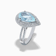The Aquarius 14K White Gold Aquamarine and Diamond Cocktail Ring showcases a pear-shaped aquamarine with a double halo of round diamonds on a white gold band, beautifully displayed against a white background.