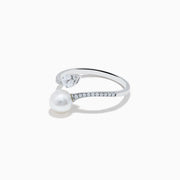 The 14K White Gold Fresh Water Pearl and Diamond By Pass Ring features a round freshwater pearl, a teardrop-shaped diamond, and small diamonds along the band, shown against a plain white background.