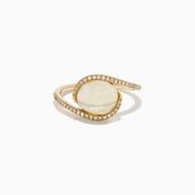 The 14K Yellow Gold Ethiopian Opal and Diamond Swirl Ring showcases a striking Ethiopian opal set in yellow gold, complemented by a swirling band adorned with sparkling diamonds.