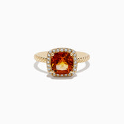 The 14K Yellow Gold Citrine and Diamond Ring showcases a cushion-cut orange citrine at the center, encircled by a halo of diamonds on a textured yellow gold band, elegantly displayed against a white background.