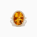 The Sunset 14K Yellow Gold Citrine and Diamond Halo Ring showcases a large oval citrine center stone encircled by a sparkling diamond halo, elegantly displayed on a plain white background.