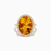The Sunset 14K Yellow Gold Citrine and Diamond Halo Ring showcases a large oval citrine center stone encircled by a sparkling diamond halo, elegantly displayed on a plain white background.
