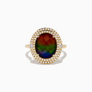 The 14K Yellow Gold Ammolite and Diamond Ring showcases a large oval ammolite center stone, encircled by two halos of sparkling white diamonds, all set in polished yellow gold.