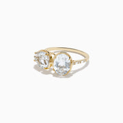 The 14K Yellow Gold White Topaz and Diamond Ring showcases two large, oval-cut white topaz stones set side by side in a minimalist, elegant style on a white background.