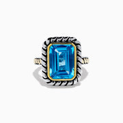 The 925 Sterling Silver and 18K Yellow Gold Blue Topaz Ring features an emerald-cut rectangular blue topaz in a twisted bezel setting with a rope-textured band, shown on a white background.