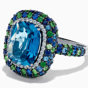 The 925 Sterling Silver Blue Topaz Cushion Multi Gemstone Halo Ring features a large rectangular blue topaz center, encircled by a halo of small white, green, and blue stones.