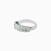 The Aurora 925 Sterling Silver Opal Ring showcases seven oval opals with iridescent hues, set closely on a sleek sterling silver band.