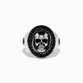 The Mens 925 Sterling Silver Black Spinel Skull Ring showcases a detailed central skull, an oval border set with black spinel stones, twisted metal accents, and small decorative side elements.